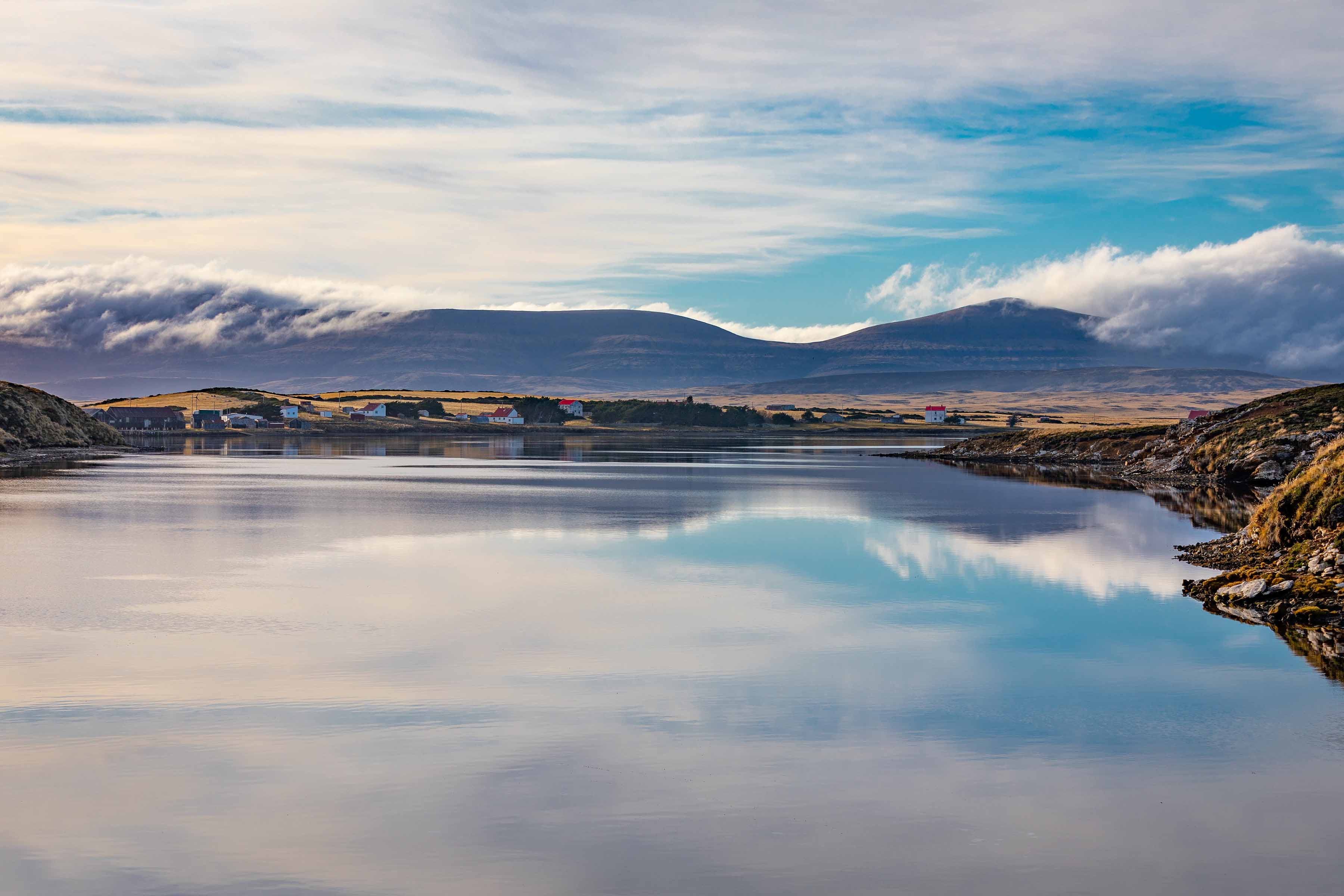 A calm shoreline and distant hills used as a second visual break